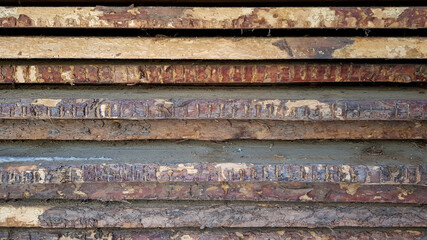 natural wooden boards stacked in a row on top of each other in a horizontal position as a background. decorative solution, shabby brown wooden planks with shabby bark. in the daytime, without people. 