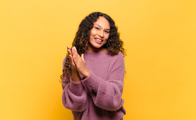 young hispanic woman feeling happy and successful, smiling and clapping hands, saying...