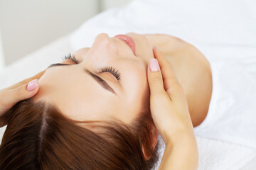 Fototapeta premium Beautiful young woman relaxing with hand massage at beauty spa salon.