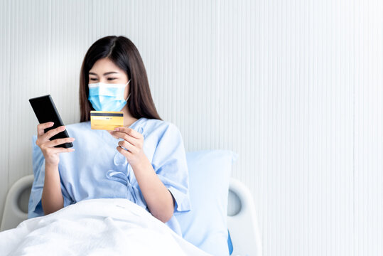 Blurred soft images of Asian attractive patient looking, Using mobile phones and mock up credit card,  for shopping online, to health care and shopping online concept.