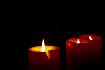 Red candle is burning on a black background