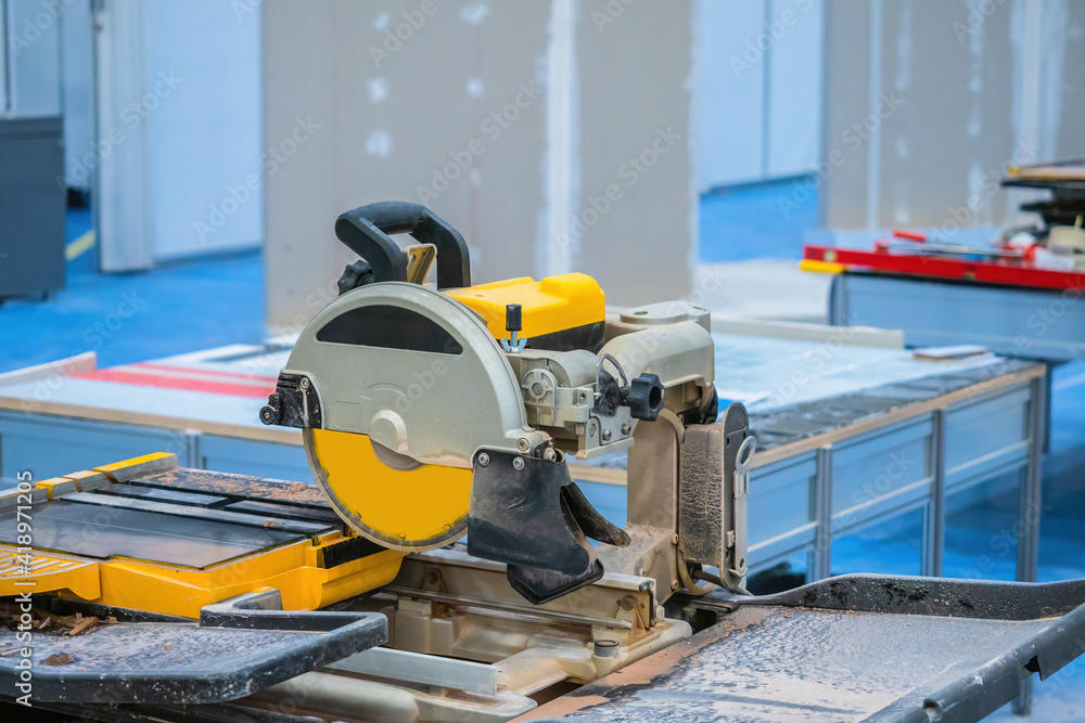 Poster circular saw in process. it is designed for cutting tiles. container of water in front of the circul
