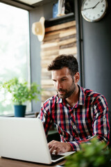 Young businessman working on laptop at office. Businessman sitting at office desk working on new project.
