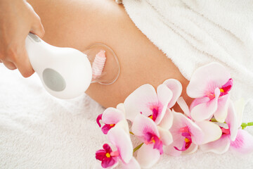 Woman getting LPG massage for skin care in home