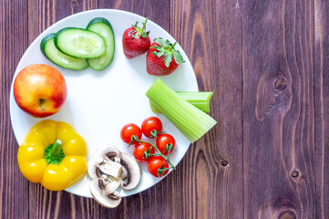 white plate, vegetables, strawberries, two eggs, mushrooms, Apple on wooden background Place for text