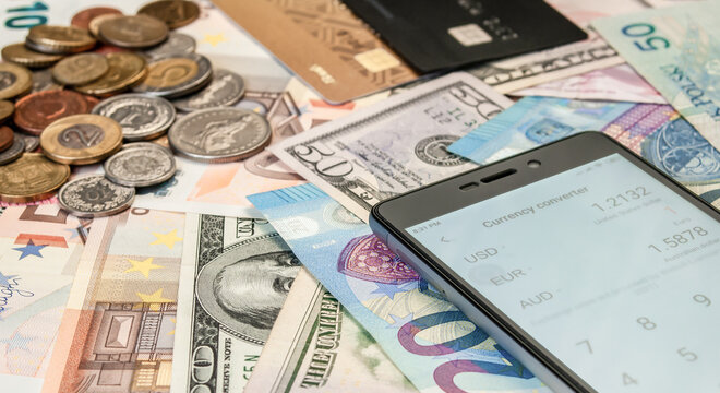 close up image of credit card, smartphone, coins and banknotes of different currencies