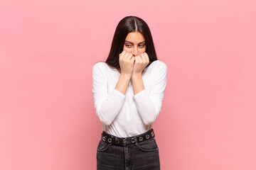 young pretty woman looking worried, anxious, stressed and afraid, biting fingernails and looking to...