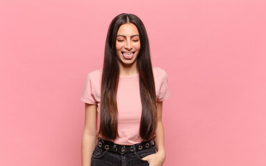 young pretty woman with cheerful, carefree, rebellious attitude, joking and sticking tongue out,...