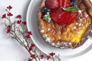 Homemade cheesecake with blueberries, currants, strawberries and mint leaves from above. Flat lay