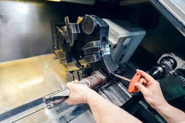 Changing the tool setup in lathe machine in production, close-up