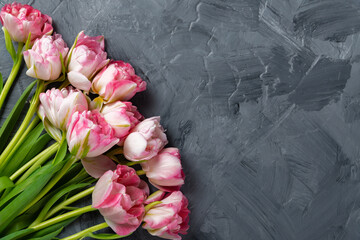 Beautiful pink spring tulips on grey background, flat lay. Space for text