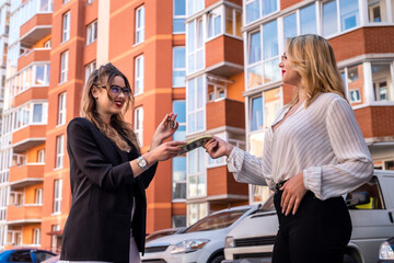 smiling woman rents a new home giving money to a realtor