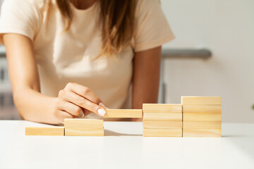 Woman hand putting and stacking blank wooden cubes on desk with copy space for input wording and...