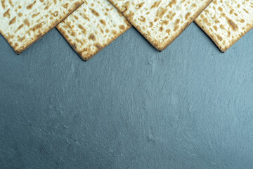 Matzah for Jewish holiday Pesach on gray marble background with copy space.