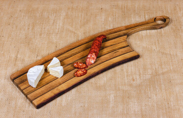 An ermine and a meat sausage sliced on a plate