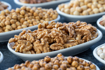 Walnut in selective focus. Nuts on plate on a dark background. Walnut, Chickpeas, White Chickpeas, Dry mulberry, almond, cashew, pistachio. Types of nuts on the plate.