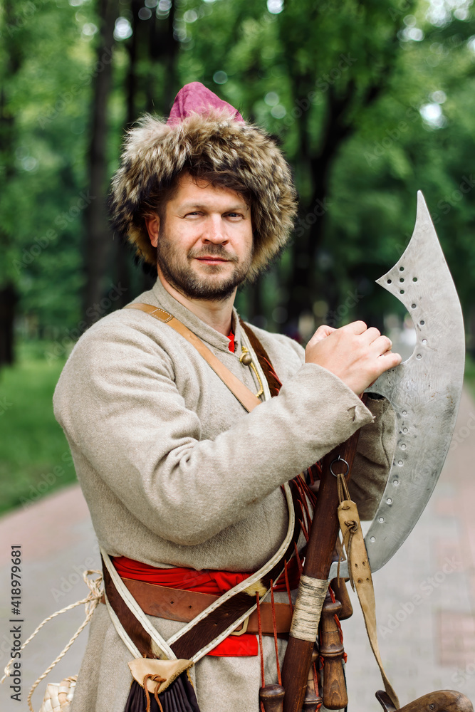 Wall mural City Cossack 1st half of the 17th century. In a caftan, a fur hat in the hands of birding. A harsh Russian man.