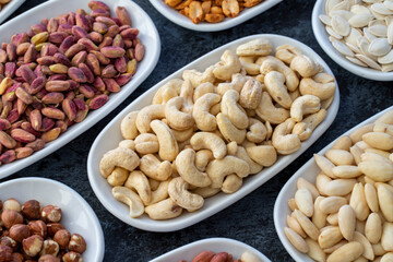 Roasted cashews in selective focus. Types of nuts found in bulk on a dark background. Top view nuts