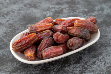 Date fruit on plate on dark background