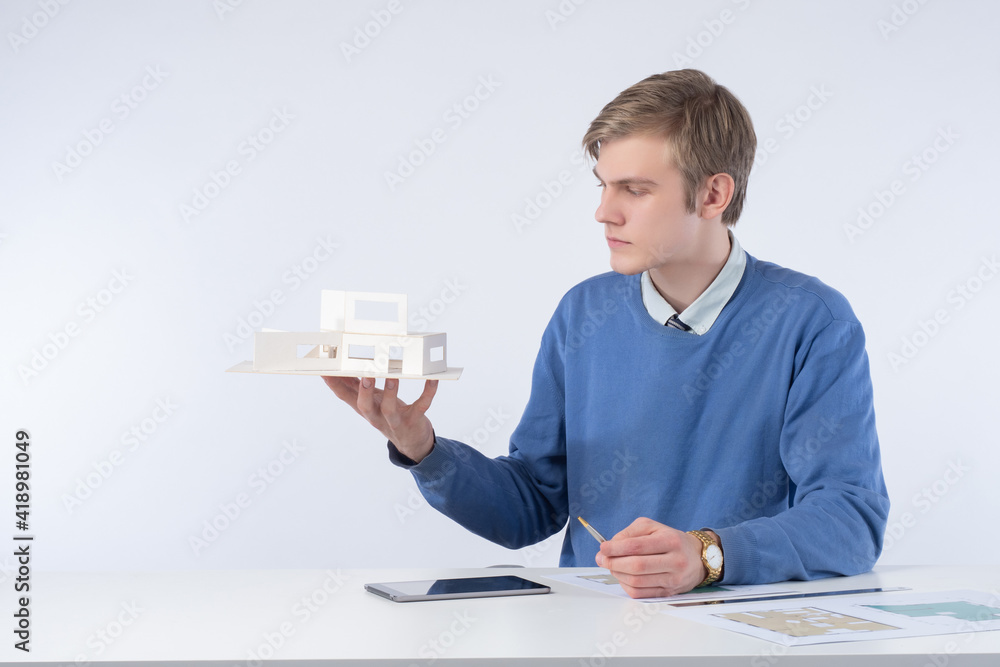 Aufkleber young architect is working on a cottage project. man with a house layout in his hands. civil enginee