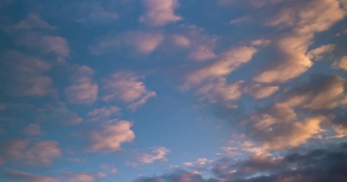 Time lapse clip of dark blue fluffy curly rolling clouds in windy weather in the evening after sunset