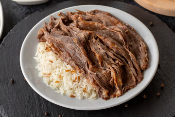 Meat on rice turns over on a dark ground. Turkish kebab doner