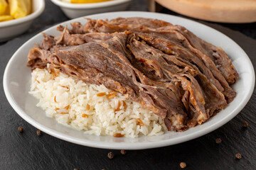 Meat on rice turns over on a dark ground. Turkish kebab doner