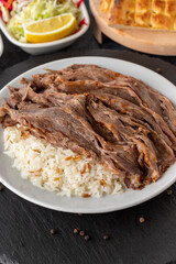 Meat on rice turns over on a dark ground. Turkish kebab doner