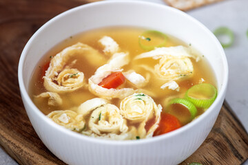 Soup on chicken broth with egg pancakes and bread matzo. Pesah celebration concept (jewish Passover holiday).