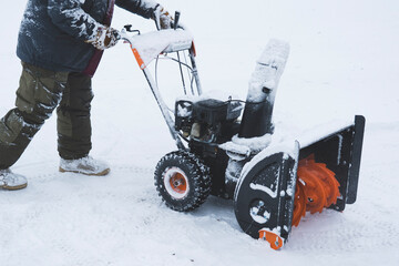 a man removes snow with a snow plow after a heavy snowfall near his house, close-up, blizzard, snow...