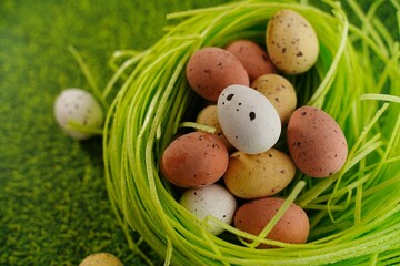 Easter freckled chocolate eggs on green grass background, selective focus