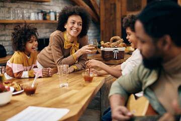 Happy black woman having fun with her family at home.