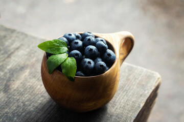 Freshly picked ripe and sweet blueberries in a wooden cup. Healthy eating and nutrition.