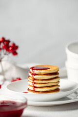 Pancakes with raspberry jam on white plate