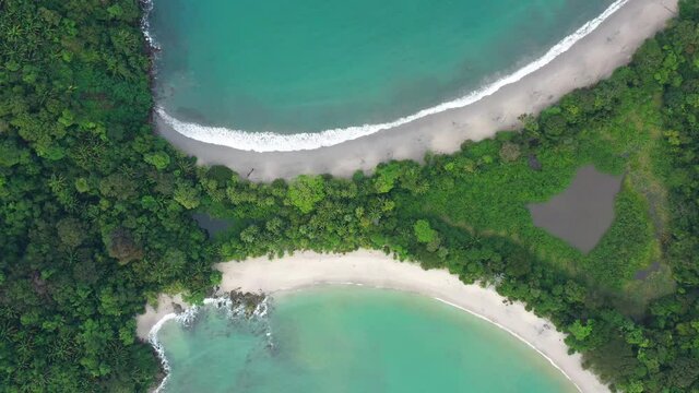 Amazing top shot paradisiac white sand beach along the jungle Manuel Antonio National Park tombolo
