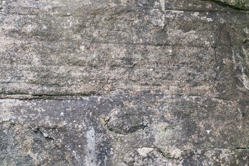 Heavily textured dark grey rocky surface with prominent horizontal lines and cracks. For use as a graphic element, a background, wallpaper or overlay layer.