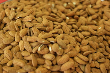 Pile of almonds close up. Peeled almond seeds background. Tasty nutritious nuts.