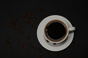 Coffee cup and coffee beans isolated on black background