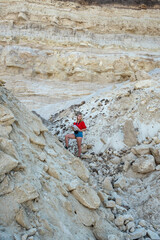 stylish young woman travels through canyons and sand rocks taking photos