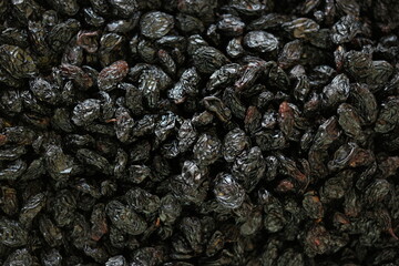 Dried black plums background. Pile of dried pruns close up. Healthy organic food.