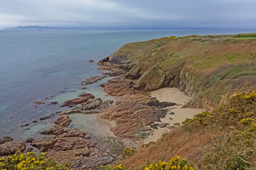 Cliffs and beach along rock coast of howth, ireland