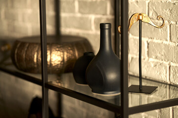 Glass shelf with black and gold decorative items.