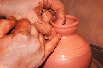 The process of making pottery. Craftsman's hands. Work on a potter's wheel.