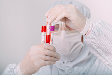 doctor man in flu mask and protective gloves holding a test tube with a coronavirus blood sample. Prevent flu disease Coronavirus.