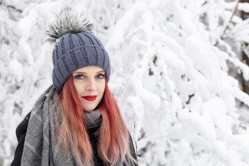 Portrait of smiling  red hair and red lips girl in snowy day. Horizontally.