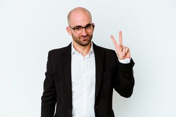 Young business caucasian bald man isolated on blue background joyful and carefree showing a peace symbol with fingers.