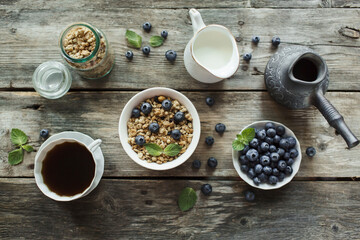 Obraz na płótnie Canvas Breakfast with muesli, fresh berries blueberries, coffee on wood background. Healthy food concept. Flat lay, top view