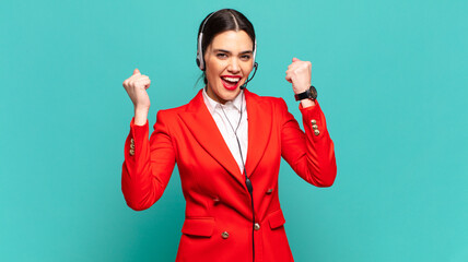 young pretty woman shouting aggressively with an angry expression or with fists clenched...