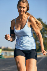 Portrait of a sporty mature woman, beautiful blonde woman playing sports in the stadium on a sunny day.