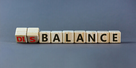 Balance or disbalance symbol. Turned cubes and changed the word disbalance to balance. Beautiful grey background, copy space. Business, balance or disbalance concept.
